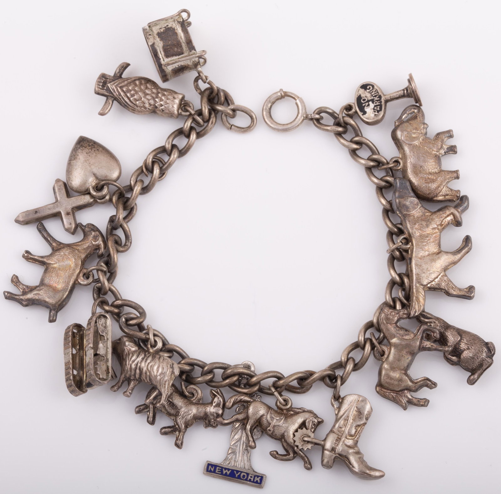 STERLING CHARM BRACELET: 16 Charms: tank, drum, owl, statue of liberty, dog, elephant, rabbit, cowboy boot with spur, horses, etc.; .86 ozt L - 7" G - VG