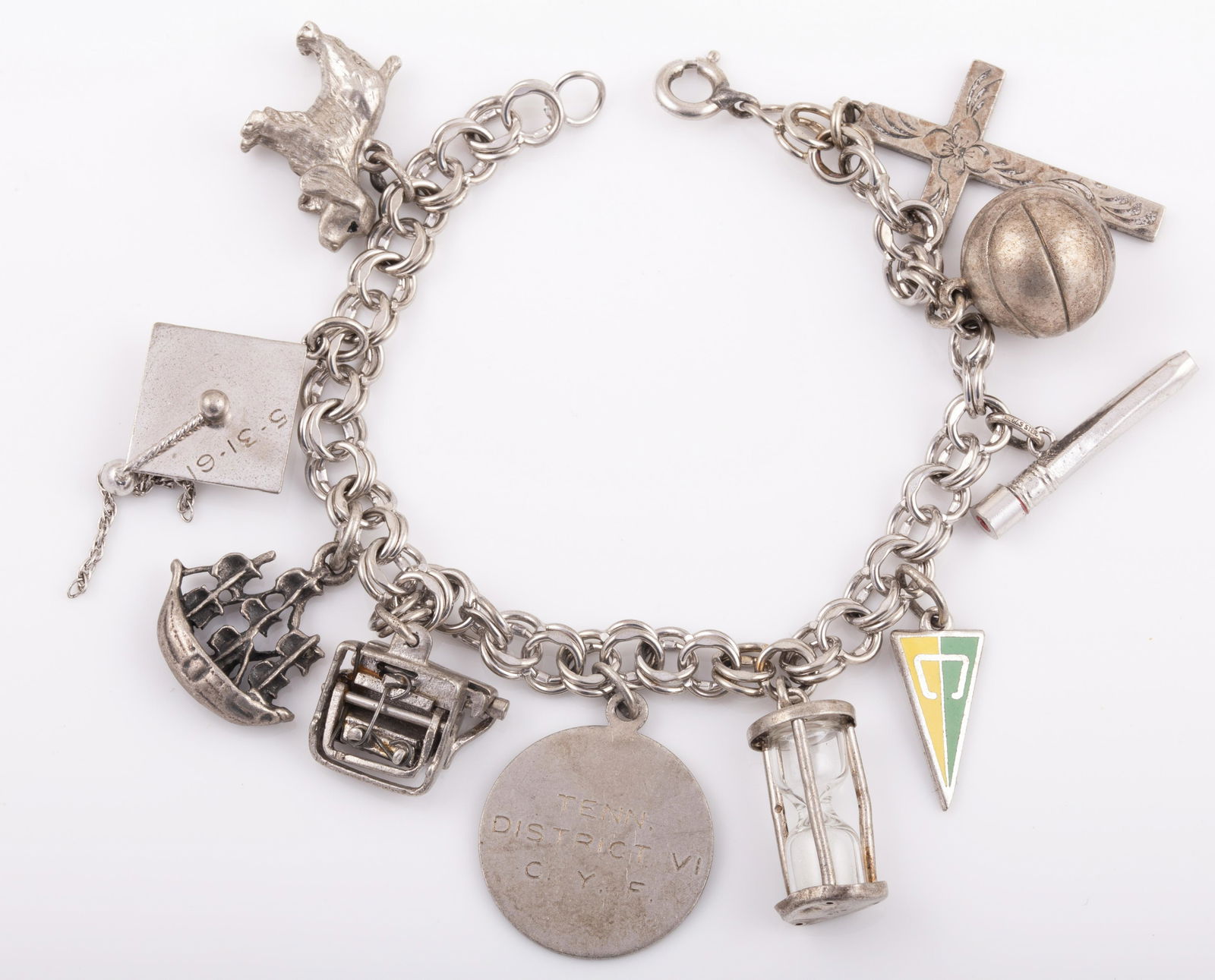 STERLING CHARM BRACELET: 10 Charms: hour glass, basketball, cross, graduation cap, dog, ship, typewriter, etc.; 1.ozt L - 7" G - VG