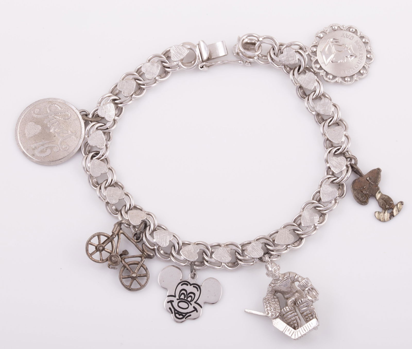 STERLING CHARM BRACELET: 6 Charms: Mickey Mouse, Snoopy, bicycle, ice hockey player, graduation day, sweet 16; .8 ozt L - 7 " G -VG