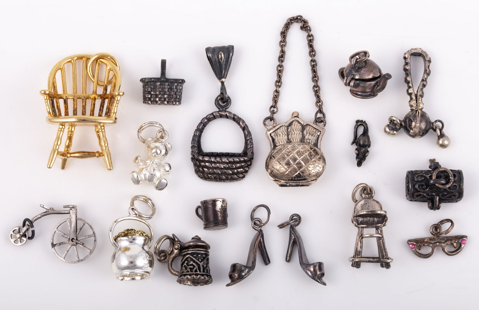SELECTION OF STERLING CHARMS (17): Includes: Cellini pot of gold charm; (2) high heel shoe; (1) sunglass charm with pink rhinestones; (1) tankard charm with hinged lid; (1) Cellini teddy bear charm; (1) hinged tea pot charm; (1) articu