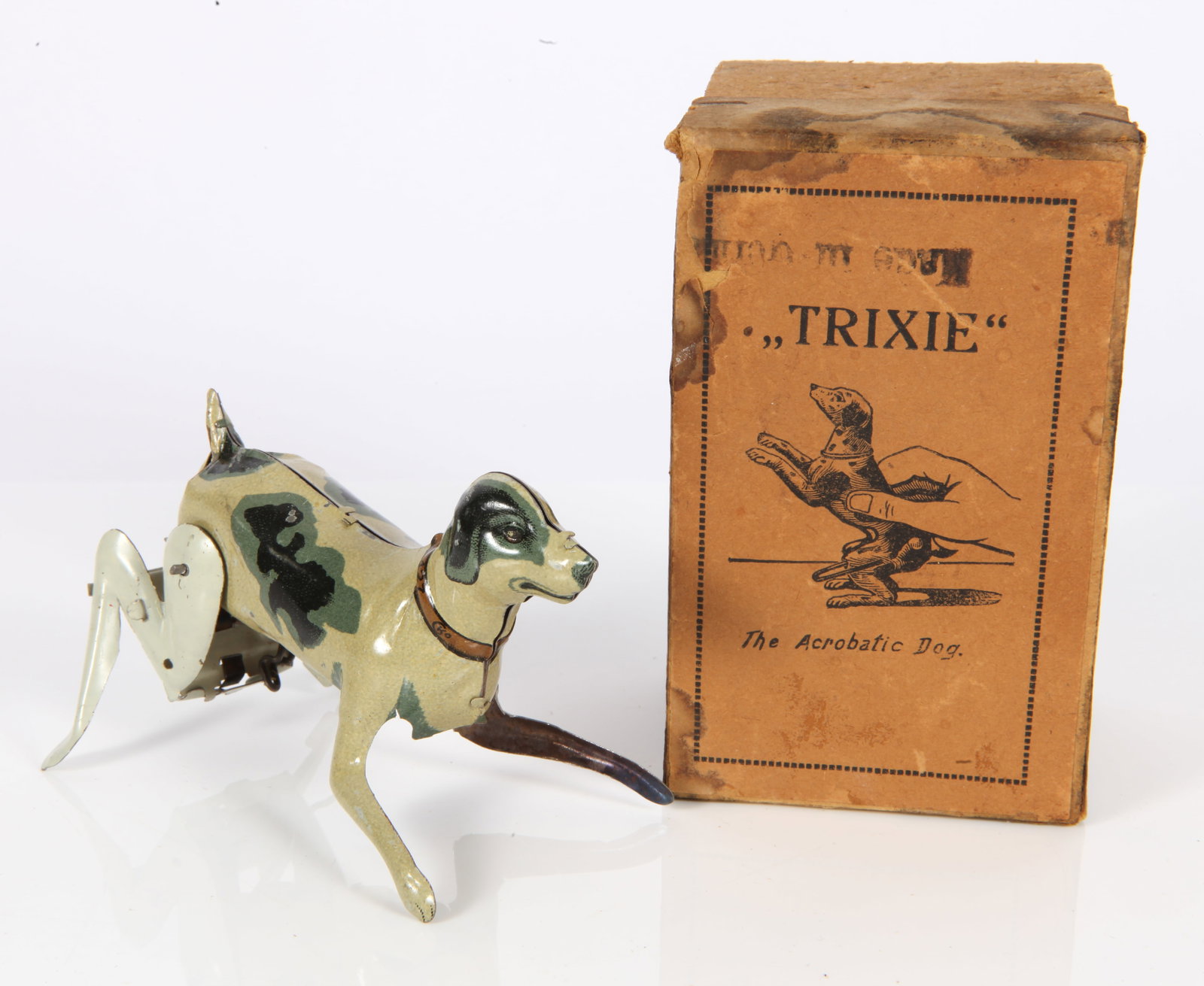 GERMAN TIN "TRIXIE" ACROBATIC DOG TOY - ORIGINAL BOX: Tin litho; action: press down on Trixie, let go and she will attempt a back flip; original instructions included; minimal paint loss; directions toned; box is in good shape; box: 4" x 2 1/2" x 2 1/2";