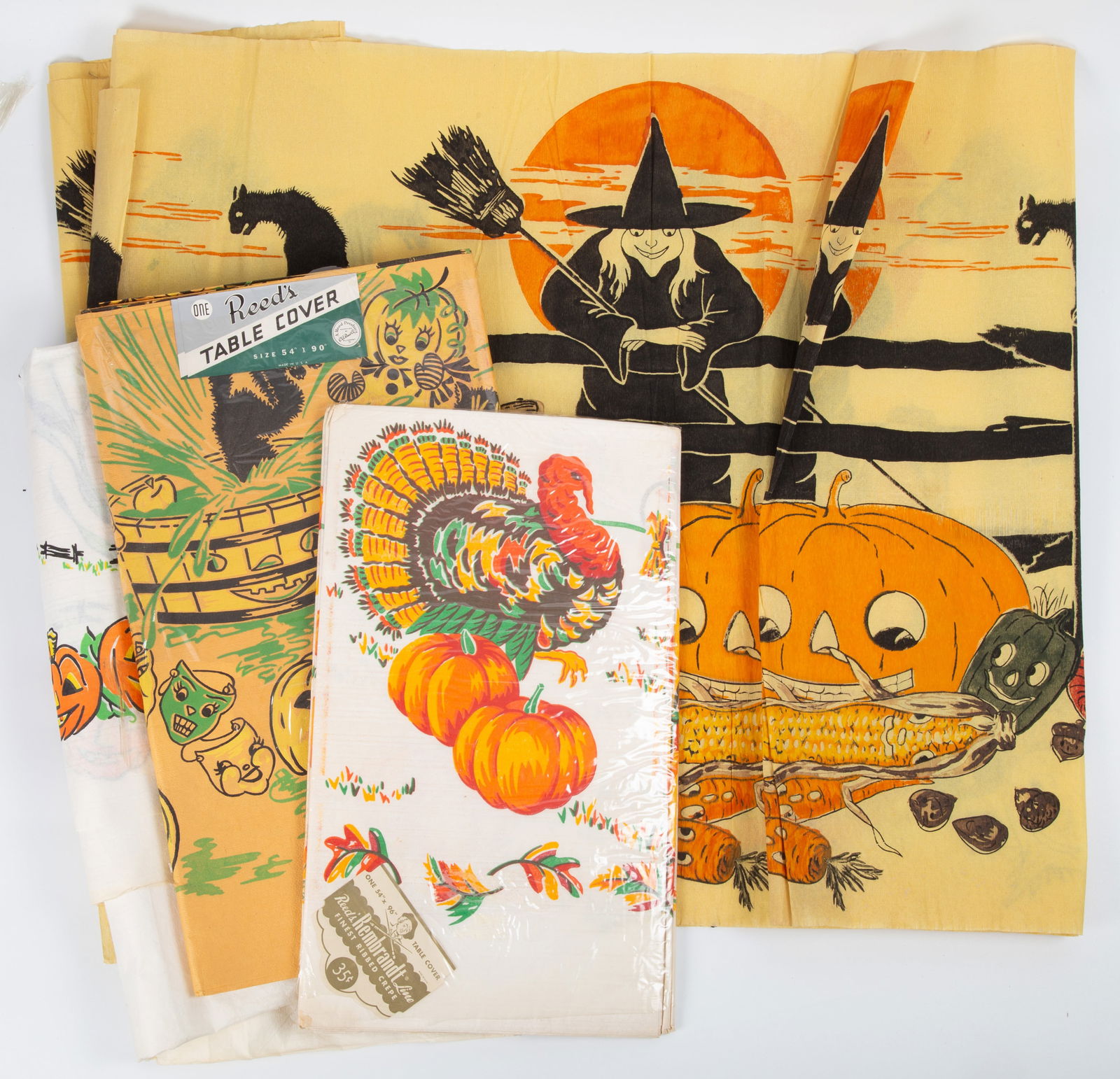 VINTAGE HOLIDAY CREPE PAPER: Tablecloths, etc.; (2) Reeds: original packaging, 1-Halloween 54" x 90"; 1-Thanksgiving 54" x 96"; (1) Halloween table runner, witches and vegetables, 8'10" x 20"; (1) Halloween table cloth 52" x 67"