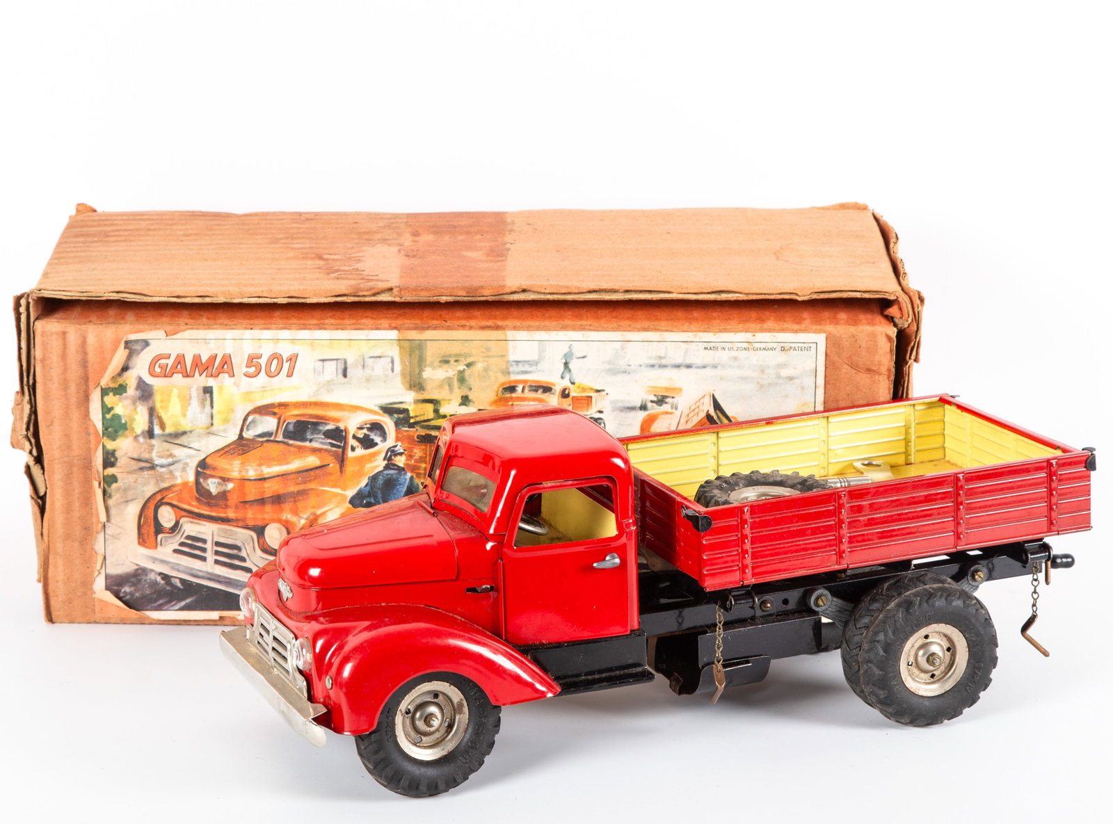 GAMA 501 CLOCKWORK DUMP TRUCK with ORIGINAL BOX: Made in US Zone Germany; painted tinplate truck; tin litho dashboard, rubber tires, retains original spare wheel, tools and key; retains paper litho brochure/insert; retains original interior box (no 