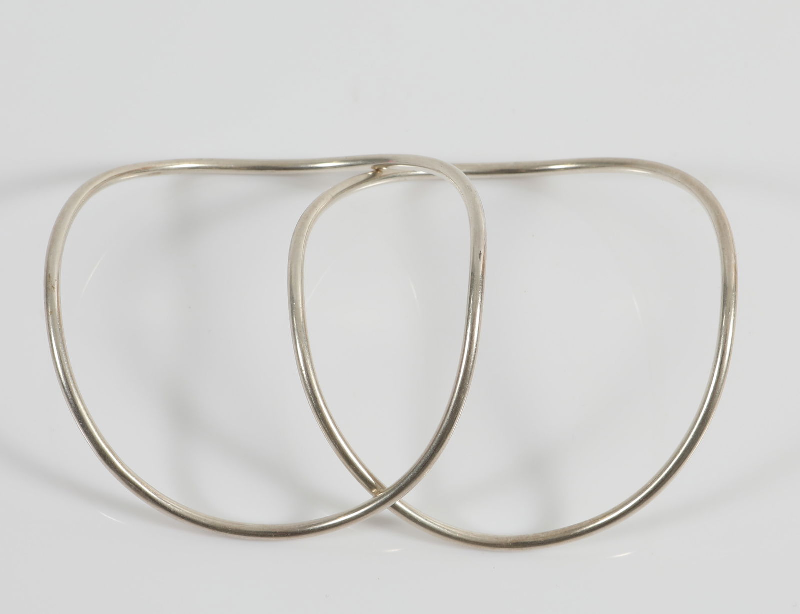 BETTY COOKE SIGNED STERLING WAVE BANGLES (2): Sterling silver wave-form bangles, each signed "Cooke", tubular form; [.80 ozt total]; interior Dia.-2 3/8", EX