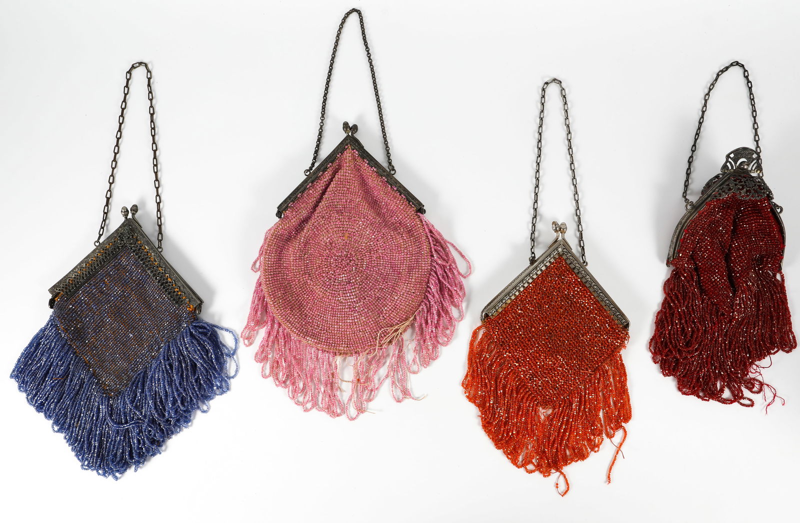 (4) VINTAGE BEADED HANDBAGS - FOR REPAIR: (1) pink beaded bag, triangular bronze tone closure, chain handle, silk lining has tears and fatigue, silk floral trim edging; beaded fringe losses; (1) orange crocheted bag with blue beading and frin