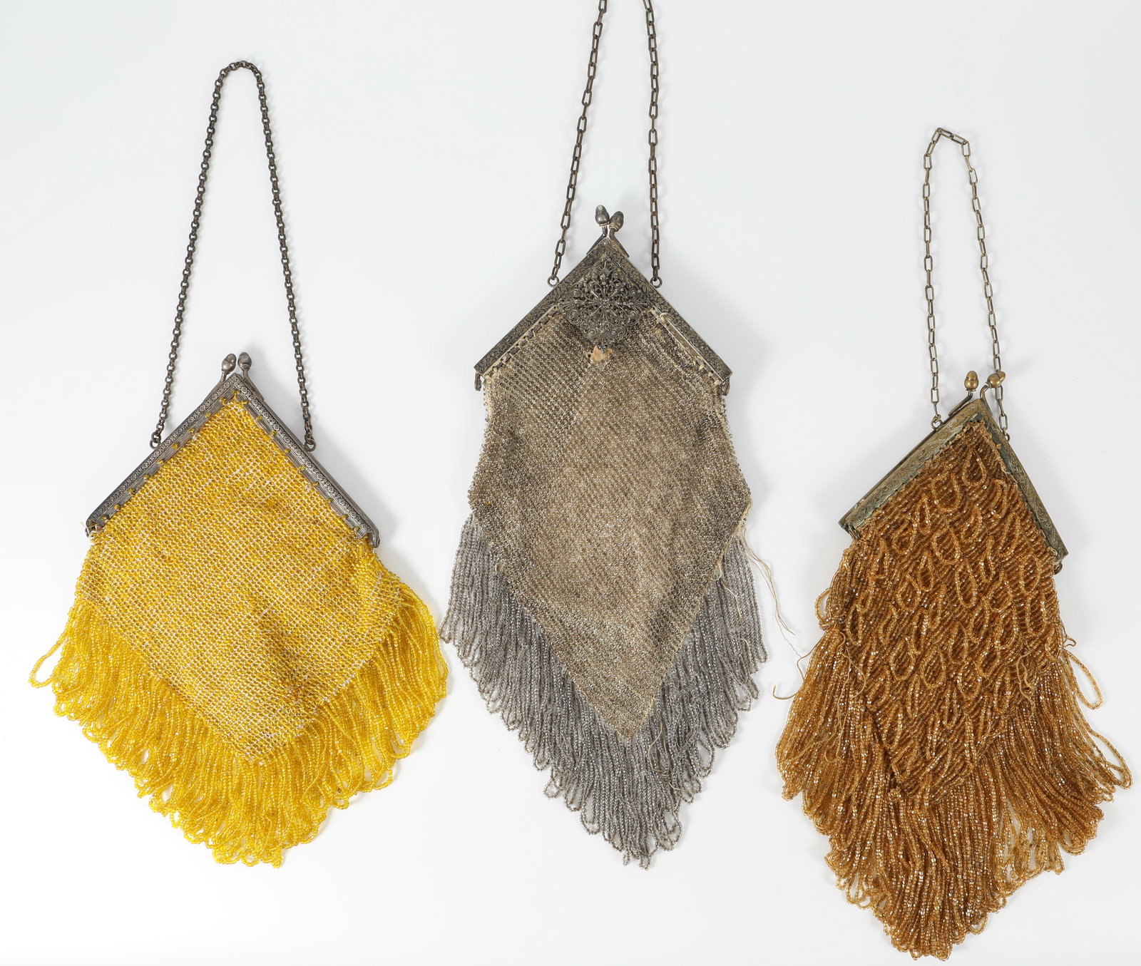 (3) VINTAGE BEADED HANDBAGS: Each bag fitted with chain handles; each with triangular frame/closure; (1) gold beaded bag, metal frame features embossed floral design; beaded fringe; together with baggie of matching yellow beads;