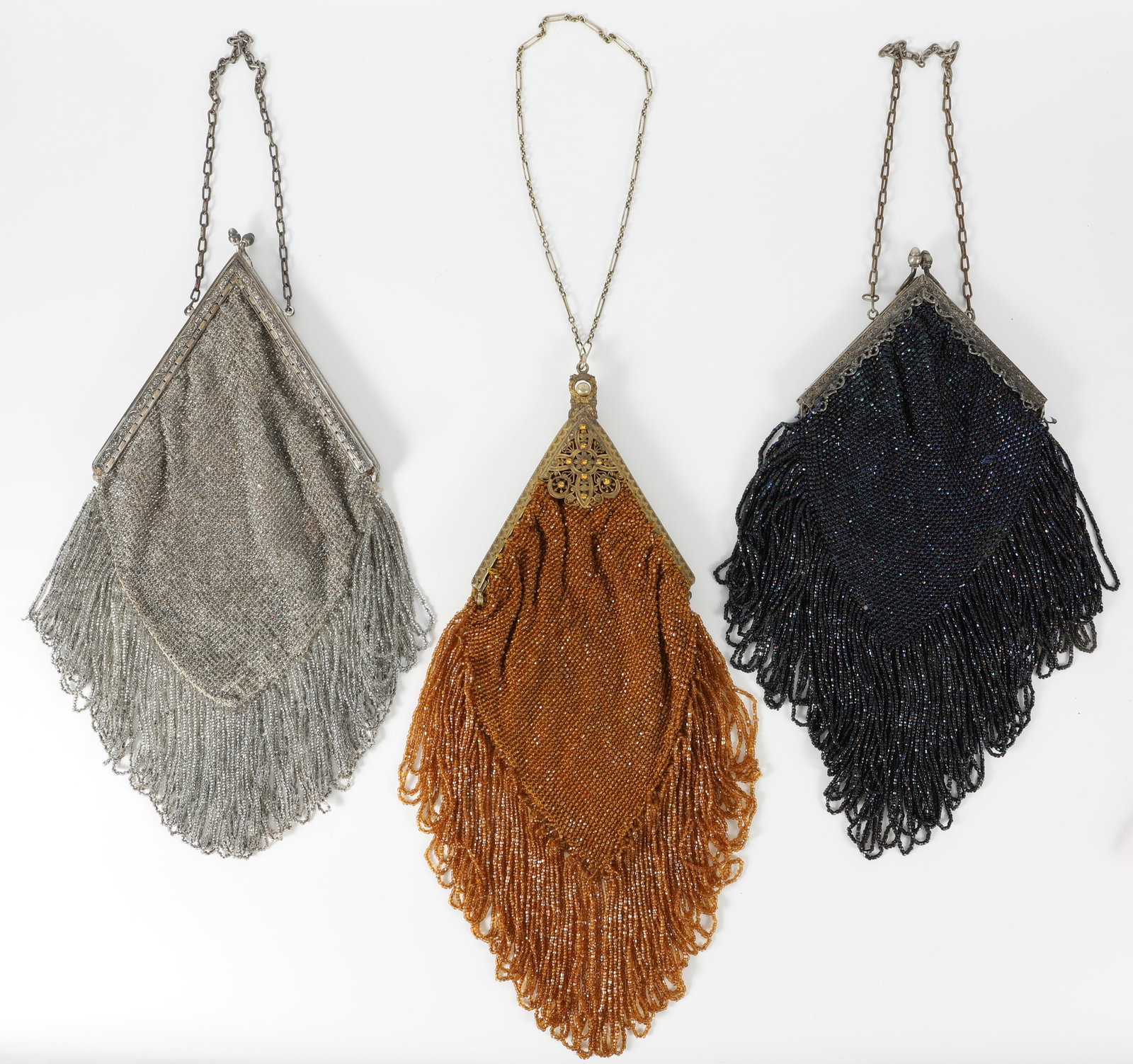 (3) VINTAGE BEADED HANDBAGS: Each bag fitted with chain handles; each with triangular metal clasp/frame; (1) clear glass beads; embossed floral metal frame; interior lined with pink satin, floral trim; beaded fringe appears intac