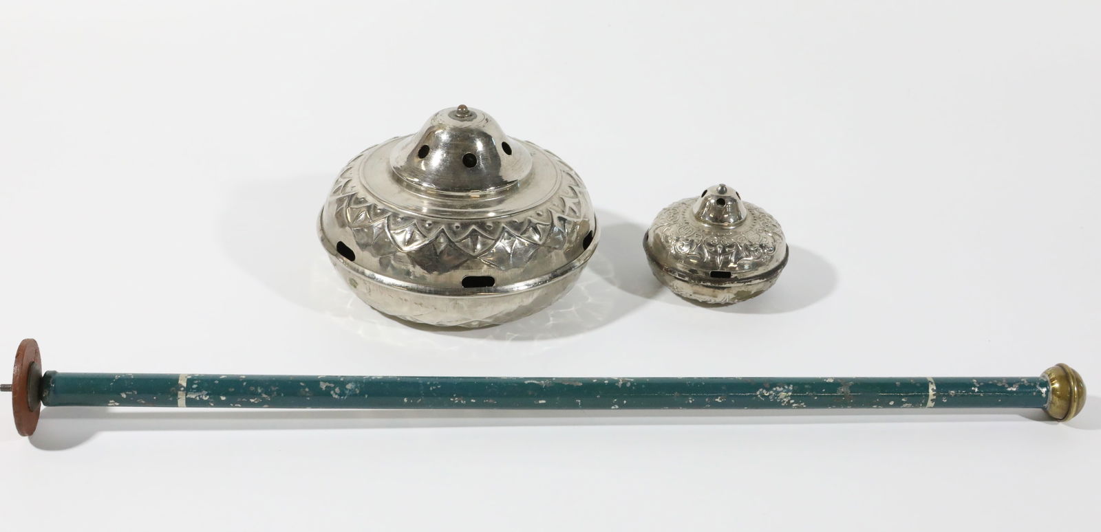 MARKLIN GERMANY SPINNING TOPS (2) and PLUNGER: Tops marked "CM" in shield, "D.G.R.M" and "PATENT"; (1) large silver tone top, Dia.-5"; spins well; (1) small silver tone top, Dia.-2 3/4", some plating loss / wear; does not spin well, possibly requi