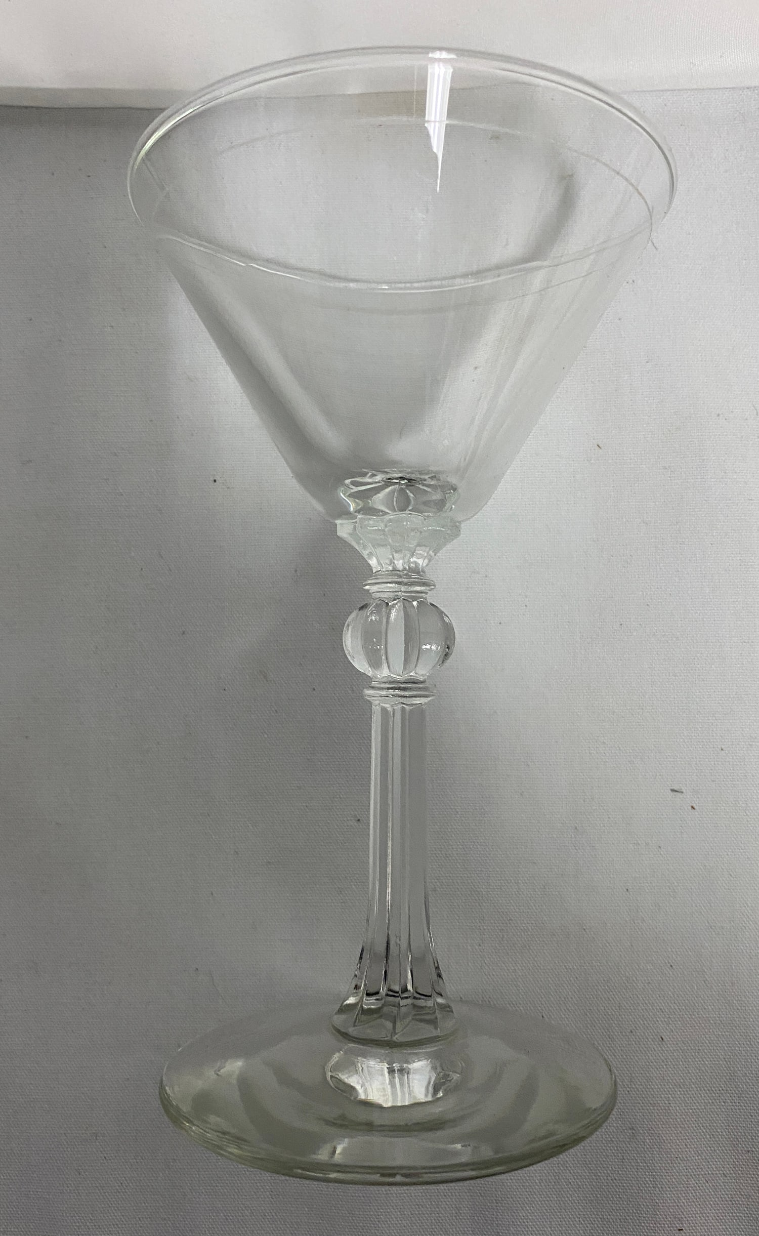 English Georgian Clear Glass Wine Glass, c. 1760-1780: English Georgian Clear Glass Wine Glass, c. 1760-1780 Hand-blown clear glass wine glass with a plain conical bowl and folded rim, raised on a molded knop stem with annulated collars and a plain disc f
