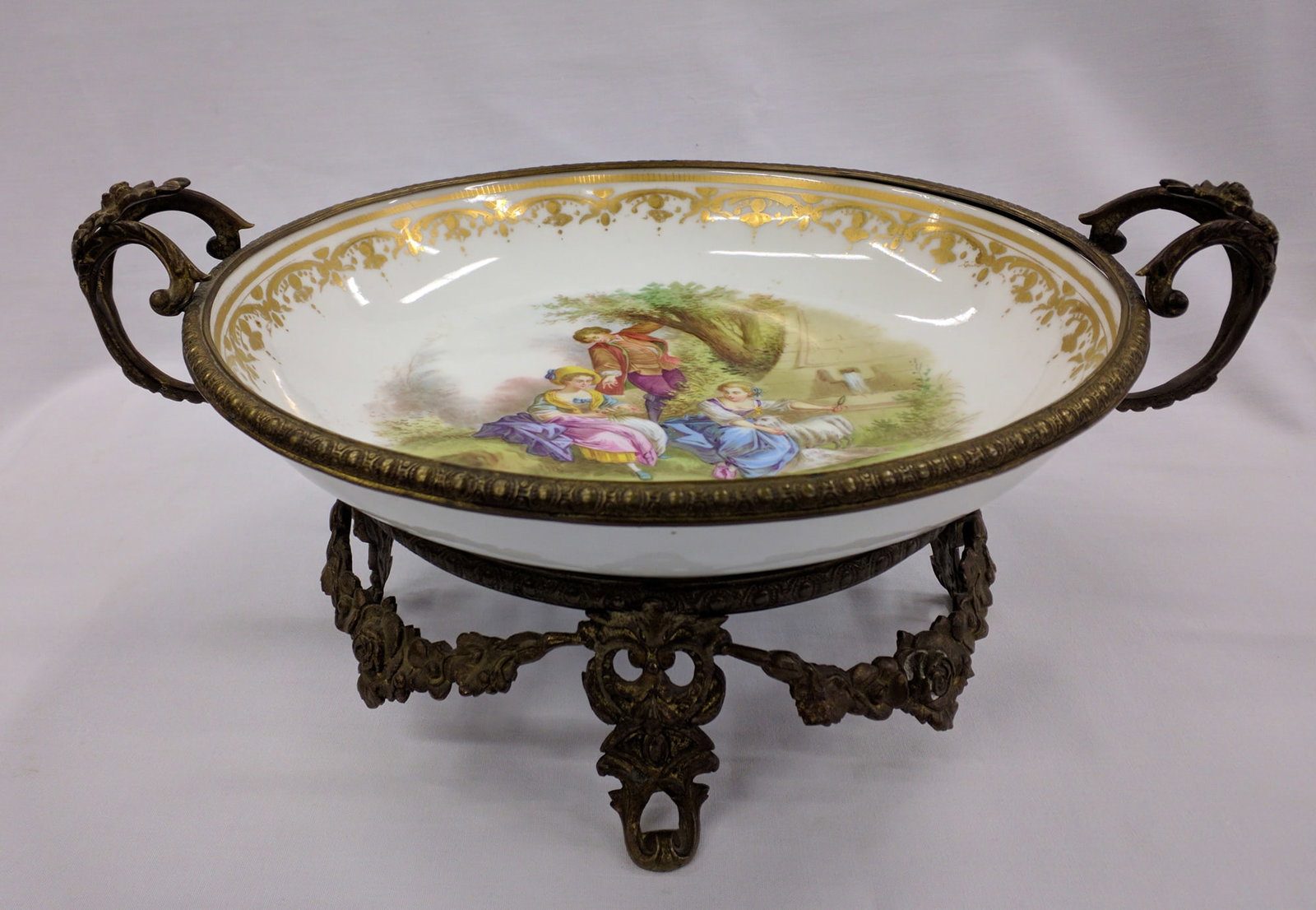 French Style Hand-Painted Porcelain and Ormolu Centerpiece Bowl: French Style Hand-Painted Porcelain and Ormolu Centerpiece Bowl A finely hand-painted French-style porcelain centerpiece bowl, mounted in an ornate gilt bronze (ormolu) stand. The interior features a