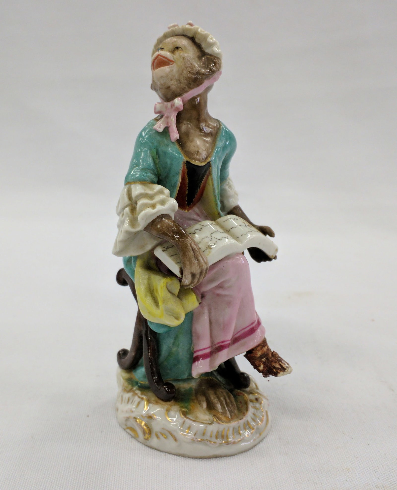 Meissen Style Porcelain Monkey Musician Figure, 18th/19th Century: Meissen Style Porcelain Monkey Musician Figure, 18th/19th Century Finely modeled and hand-painted porcelain figure of a monkey seated on a Rococo-style base, dressed in 18th-century attire with a teal