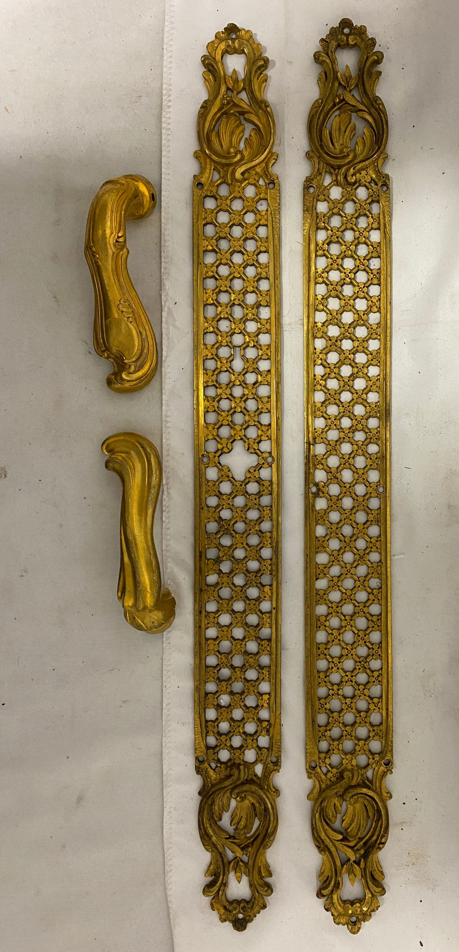 Pair of Louis XV Style Gilt Bronze Door Backplates with Handles: Pair of Louis XV Style Gilt Bronze Door Backplates with Handles A finely cast pair of Rococo-style gilt bronze door escutcheons, each with intricate pierced latticework and foliate scrolls at top and