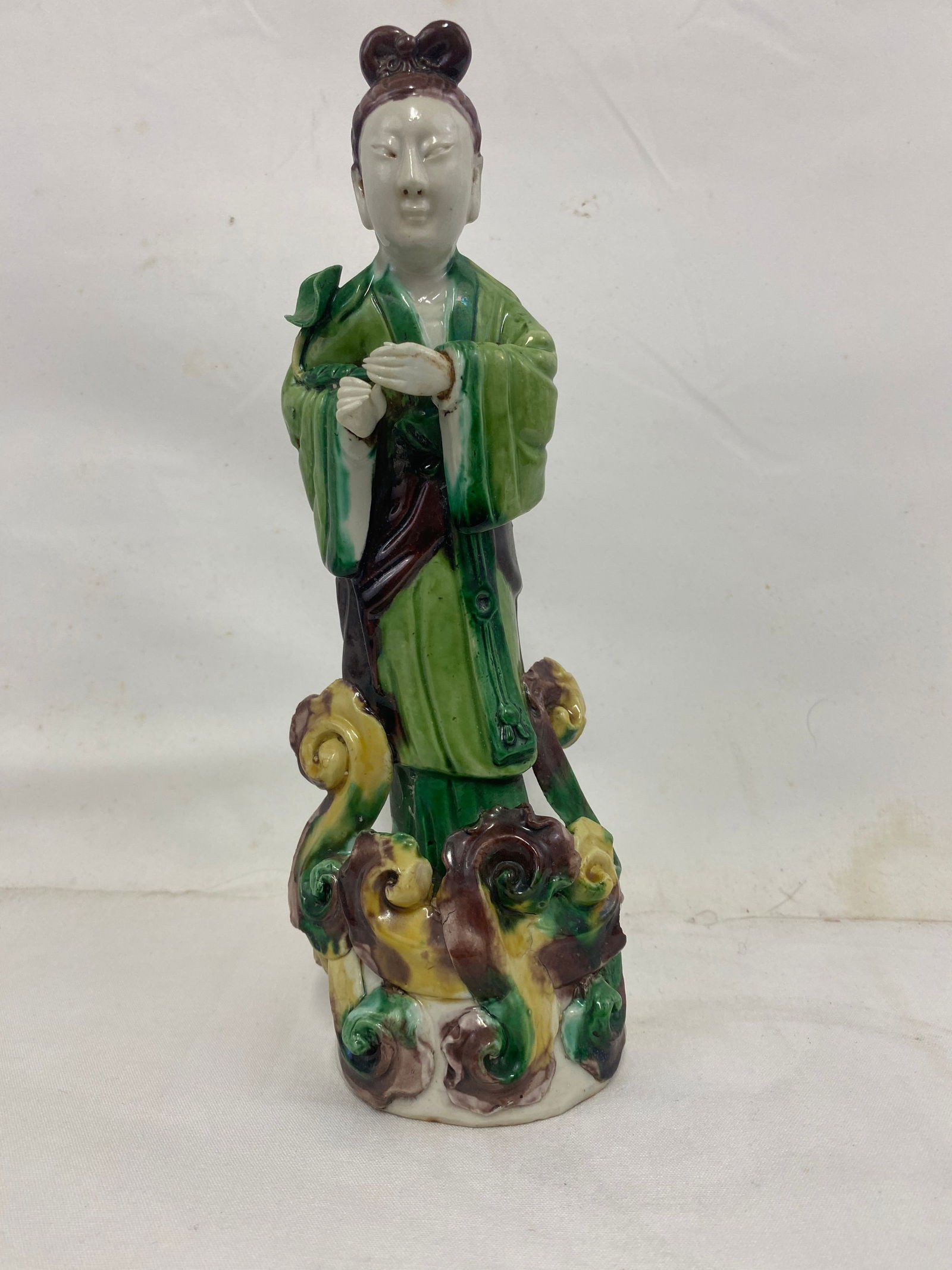 A finely modeled and glazed Chinese porcelain figure of a court lady: A finely modeled and glazed Chinese porcelain figure of a court lady, attributed to the Dehua kilns, Fujian Province, mid-20th century. The figure stands gracefully with hands clasped in front, dresse