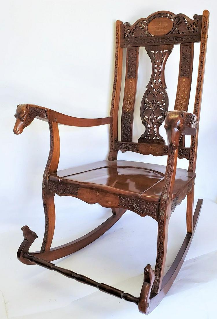 Hand Carved Rocking Chair With Floral and Camel Design: hand Carved oak rocking chair with beautiful ornate floral design with hand carved camel arm ending. There is a beautiful brass inlay through out the design that adds a subtle and extravagant touch to