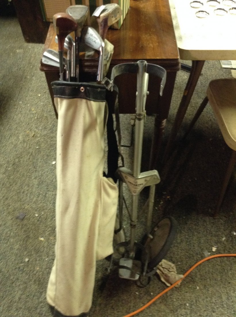 Golf clubs and golf caddy: Golf clubs and golf caddy as seen in photo