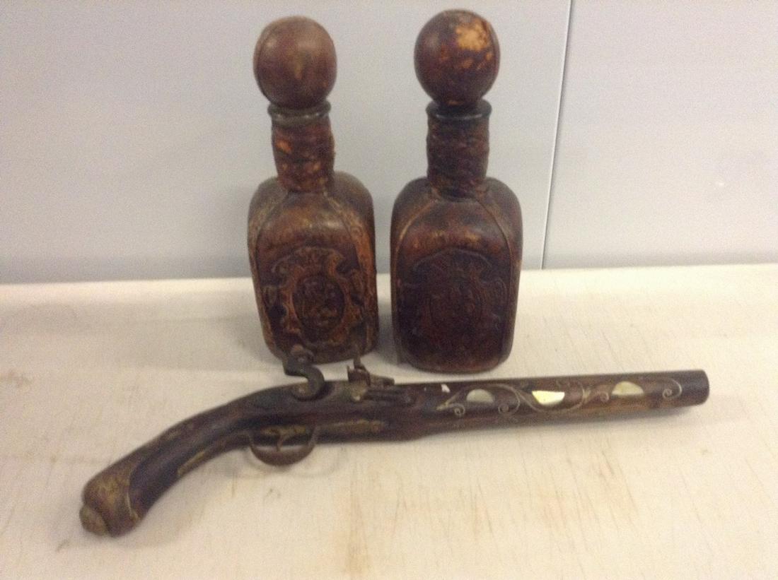 2 hand tooled leather decanters and wall decoration: 2 hand tooled leather decanters and wall decoration flint gun
