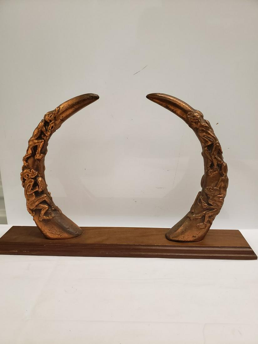 Unique gold horns mounted on wooden base - horns appear: Unique gold horns mounted on wooden base - horns appear to be carved showing figures climbing up them