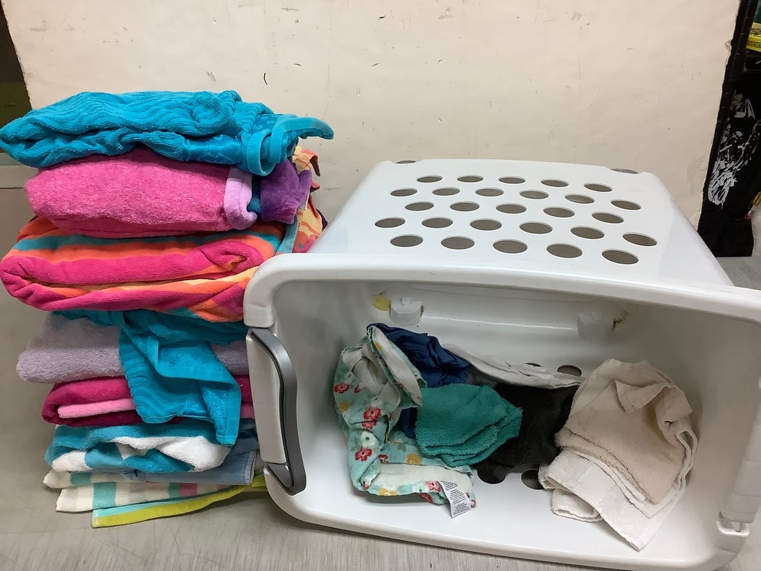 Laundry basket with wheels(19in.tall, missing handle) and various washcloths/towels (1 of 1)