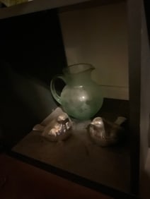 green pitcher and bird stautes