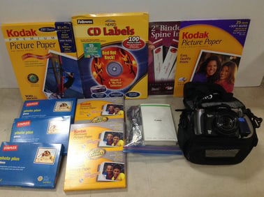 Canon Powershot XS10 camera with case, Kodak picture paper, Staples photo pluss gloss paper, and