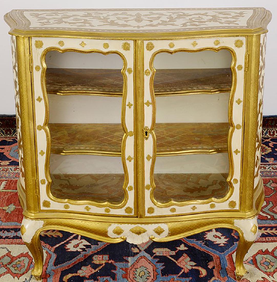 A Pair Venetian Rococo Style Glass Fronted Cabinets: This lot consists of a Pair Venetian Rococo Style Glass Fronted Cabinets which have been Hand Painted Gold and White and crafted out of wood with glass fronted cabinets. There is a cabinet on the bott