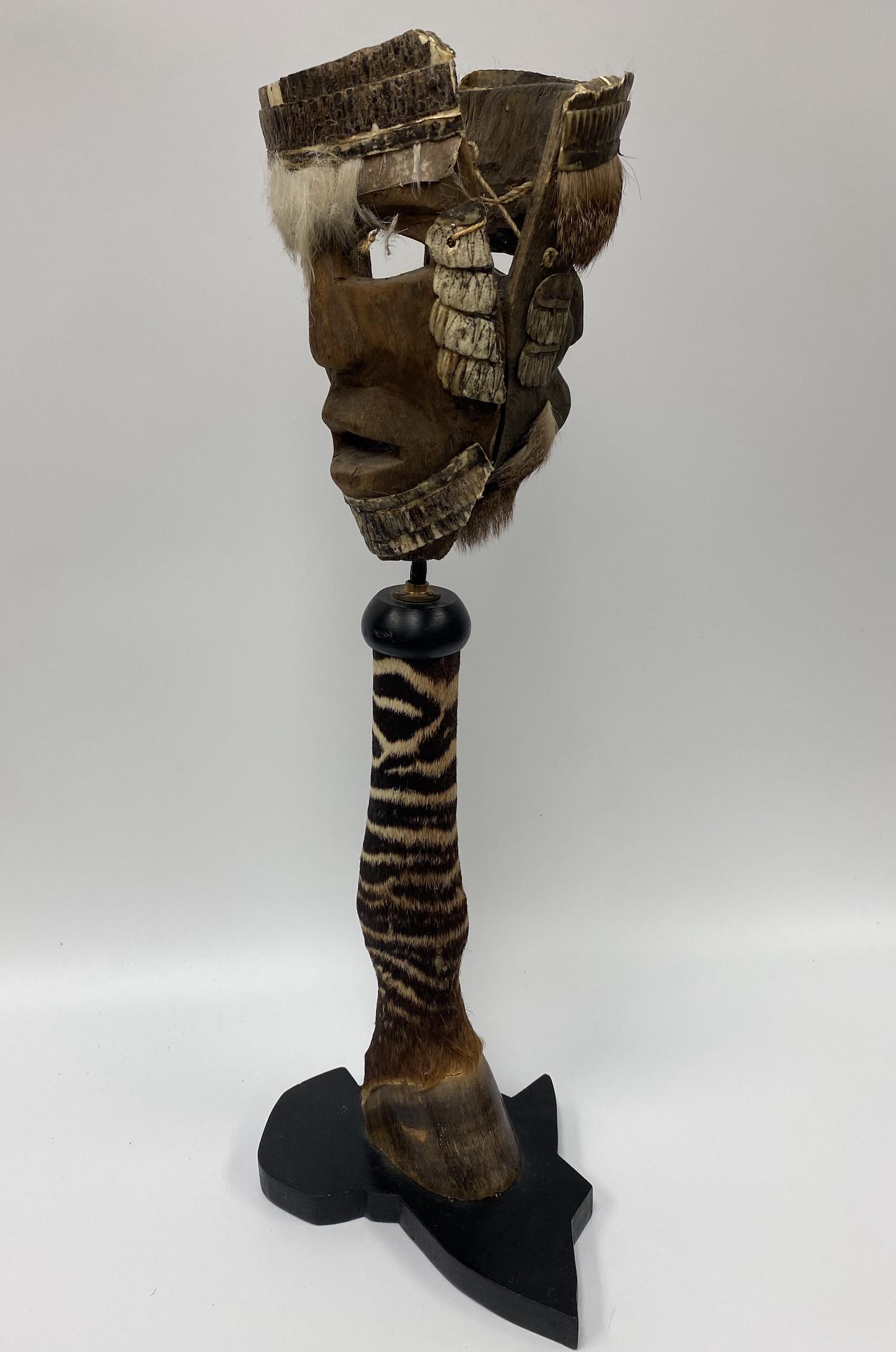 African Masks with Zebra Hoof Stand: Pair of African Masks with Zebra Hoof Stand. Measures 23 1/2 H x 9 3/4 W x 7 D