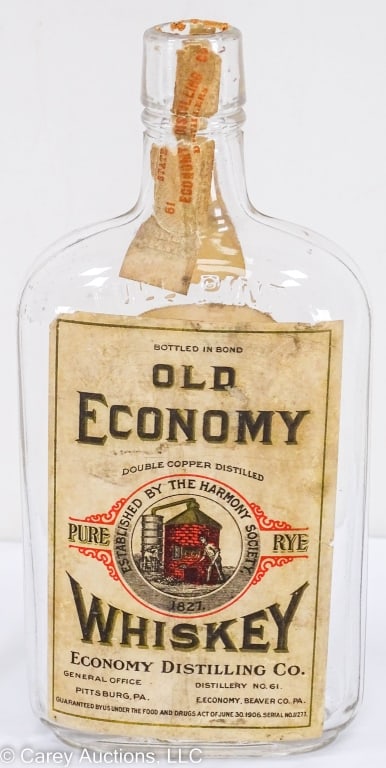 RARE HARMONITE OLD ECONOMY WHISKEY FLASK: A pint whiskey flask with an original Old Economy Distilling Co., Pittsburg, PA label. Likely prohibition era, with a 1914 permit label B-184 for medicinal purposes only. / Measures: 8" high, 4" wide