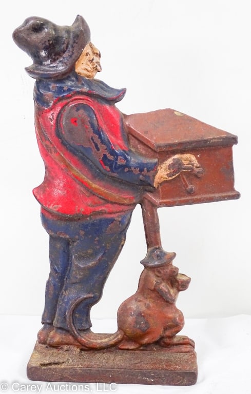 ORGAN GRINDER AND MONKEY CAST IRON DOORSTOP: 1915-1930 cast iron organ grinder and monkey double-sided doorstop. Retaining 80 to 85 percent of original paint. Nice details on both sides. / Measures: 10"H X 2.5" W X 4.75" L / Condition: Nice cond