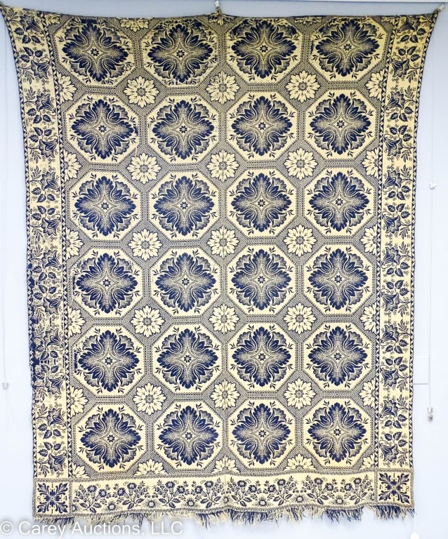 19TH C. BLUE AND WHITE FLORAL COVERLET 1841: A blue and white floral coverlet, center seam with (1841) woven at two corners. / Measures: 72" x 92" / Condition: Fringe on one end, some areas of wear and tear, and small holes.