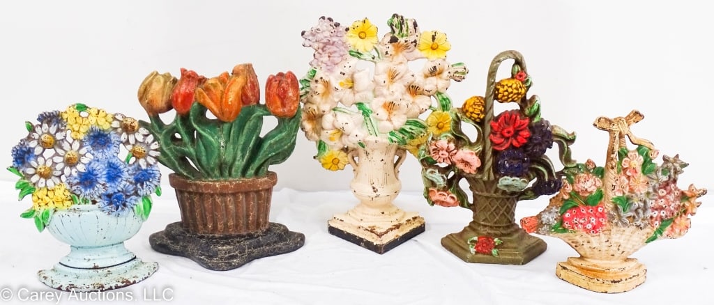 FIVE CAST IRON DOORSTOPS FLOWER BASKETS: Four with original paint. Tulips appear to have been repainted. Three are marked on the back. [#89], [#475], [#452]. These range in size from 10" H X 3" W X 7.5" L to 7" H X 1.5" W X 7" L.`` / Conditi