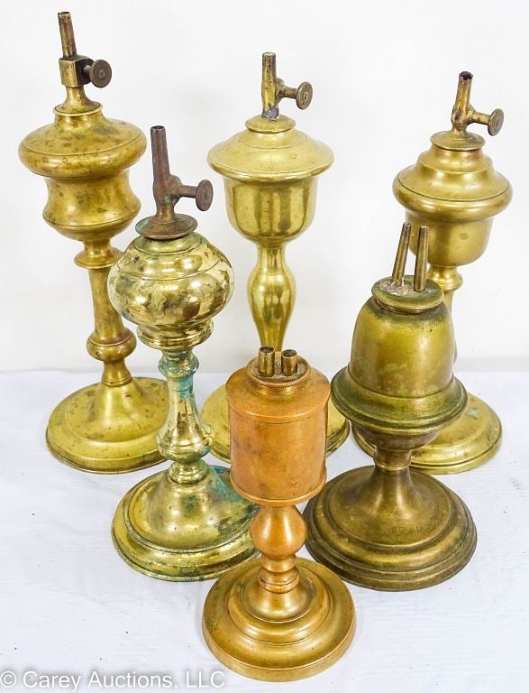 6 19th C BRASS WHALE OIL FLUID LAMPS INCL GARDON: Early to mid 19th Century whale oil fluid lamps. 5 are made of cast brass, 1 is stamped brass. All have their burners, the 4 tallest ones are marked [GARDON] on the turn knob. / Measures: 6.5"H t