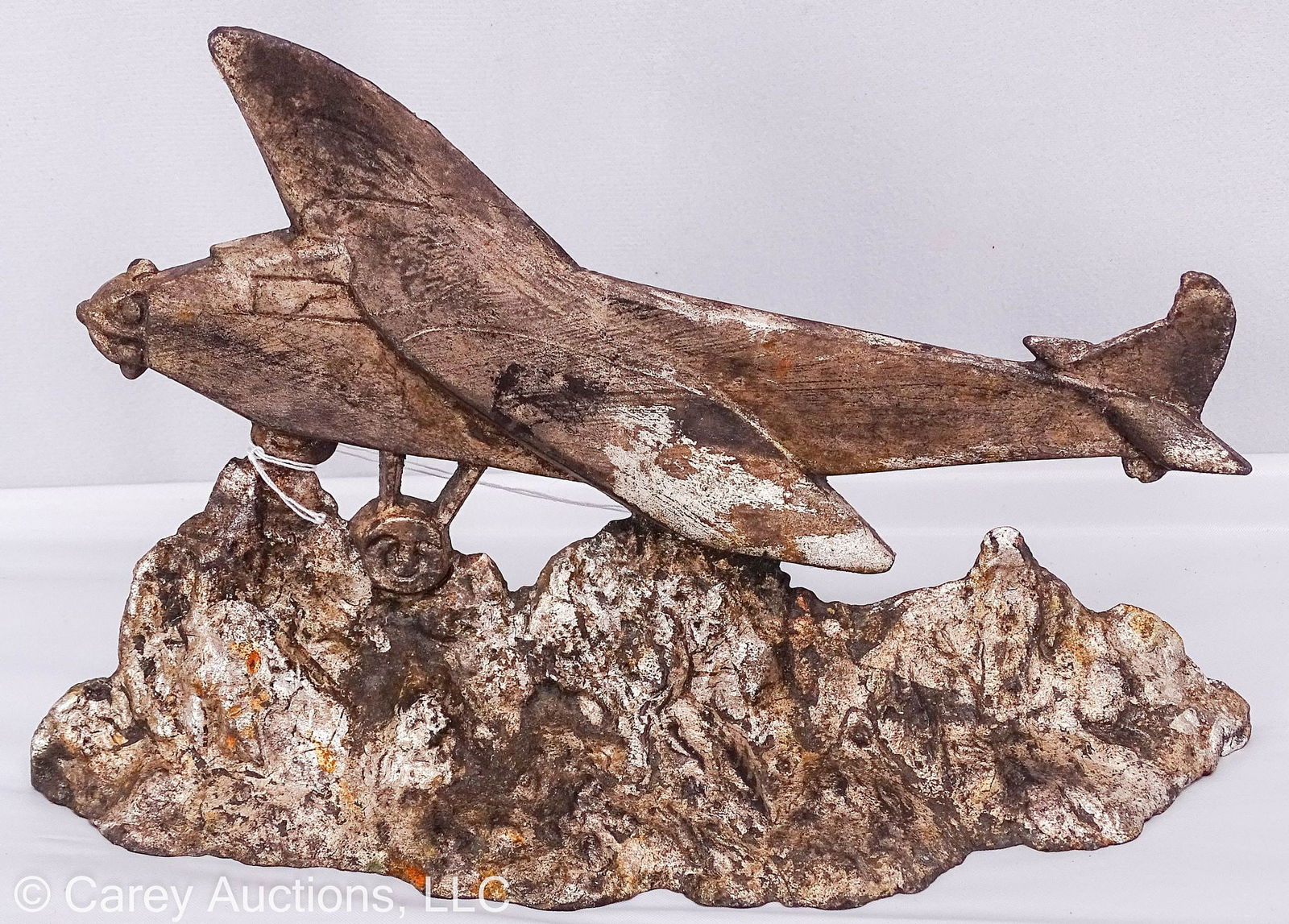 CAST IRON SPIRIT OF ST LOUIS DOOR STOP: Cast iron door stop made by LVL of Charles Lindbergh's plane "The Spirit of St Louis"; Silver paint appears to be original; marked on back [PAT APPLIED FOR LVL] // Measures: 6"H x 9