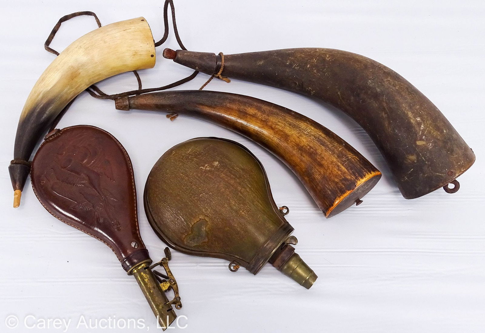(5) ASSORTED POWDER HORNS & FLASKS: Includes: (3) Powder horns, 9"-12"; (2) flasks - one leather embossed with game, brass tip marked [3lbs] and one carved horn and brass; both flasks for lead shot // Condition - wear & so