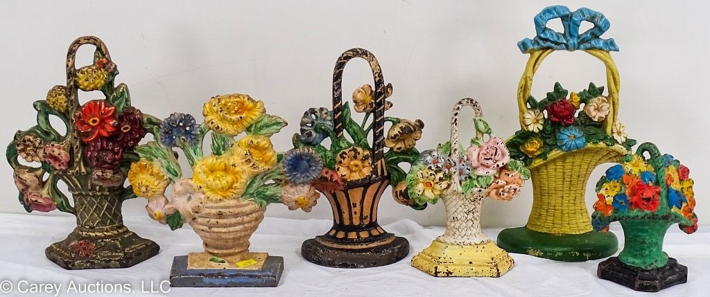 SIX CAST IRON DOORSTOPS FLOWER BASKETS: Appears to be original paint. Some have marks and numbers on reverse. [65], [182], [304], [152] and one marked [MADE U.S.A.]. Ranging in size from 10.5" H X 2" W X 6.5" L to 5.75"