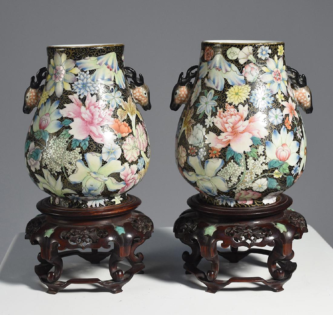Pair Chinese Famille Noire floral decorated Hu vases: Pair Chinese Famille Noire floral decorated Hu vases, with deer handles, and jade inset rosewood bases. Vase 6.5”H., 9.5” overall, signed on bottom very well painted. 