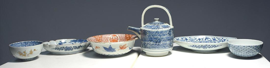 Six pieces of Japanese ceramics 19th C.: Six pieces of Japanese ceramics 19th C., blue & white teapot, three blue & white low bowl and serving dishes, one blue & white floral inside, gilt decoration on exterior, one 6.25” orange palett