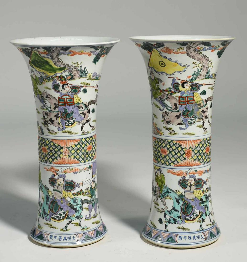 Pair of Chinese Beaker Form Famille Verte Vases: Pair of Chinese porcelain beaker form vases in famille verte palette. Scenes depicting warriors on horseback, with underglaze reign marks at base. 16.75”H x 9” dia. at rim. Each weighs 6.5 lbs.