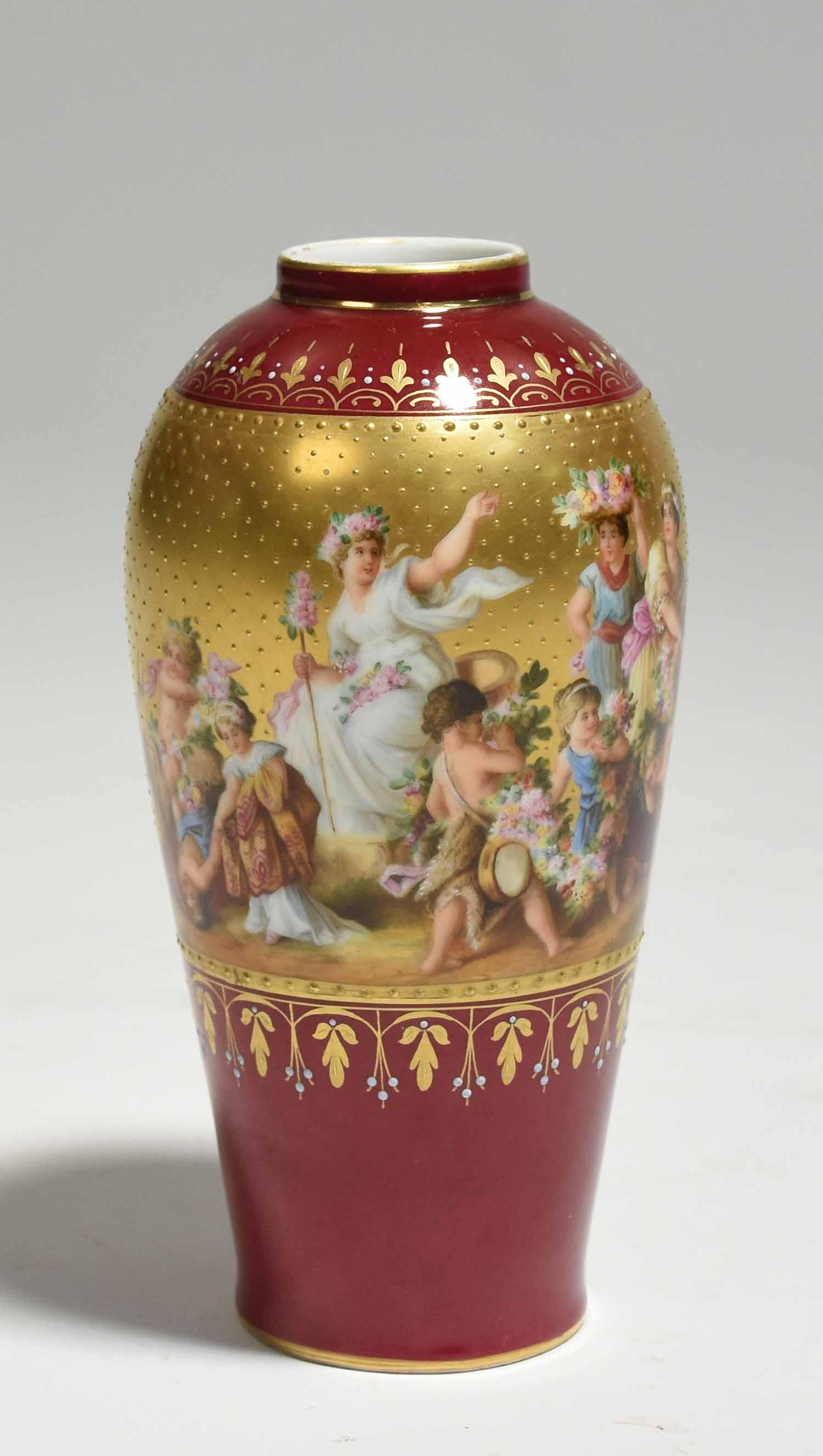 Royal Vienna Hand Painted Porcelain Vase: Royal Vienna hand painted porcelain vase with a Classical bacchanal scene atop a maroon and gilded ground, ca. 1900, 6.25”H. 