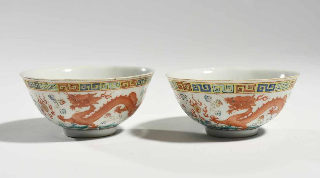 Pair of Chinese Porcelain Bowls: Pair of Chinese porcelain tea bowls with six-character reign mark on bottom, exterior with dragon and phoenix decoration, interior with bat decoration. 4.75” dia. x 2.25”H.