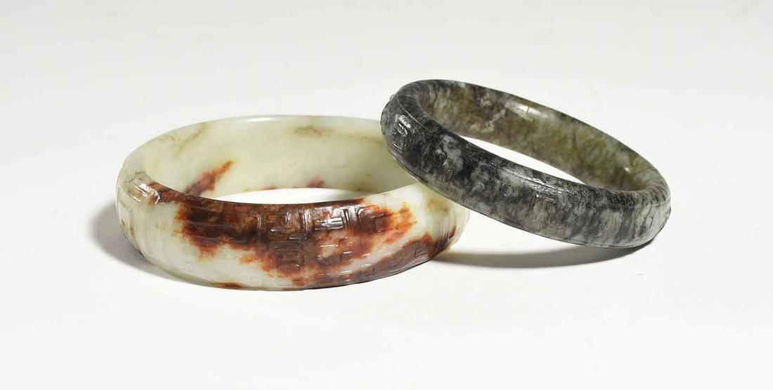 Two Jade Bangles: Two jade bangles including example with russet veining 3.5”Dia, and other olive green example 3”dia. 