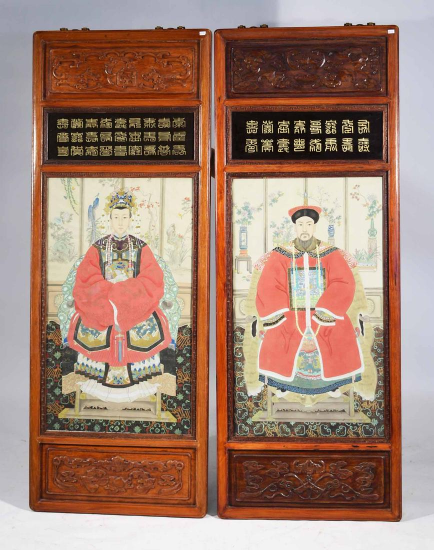 Pair of Chinese Ancestral Portraits: Pair of Chinese ancestral portraits, paintings on paper of Emperor and Empress in carved rosewood panels, with reverse painted on glass calligraphy, bottom and top frieze carved with bats, 20th C. Pai