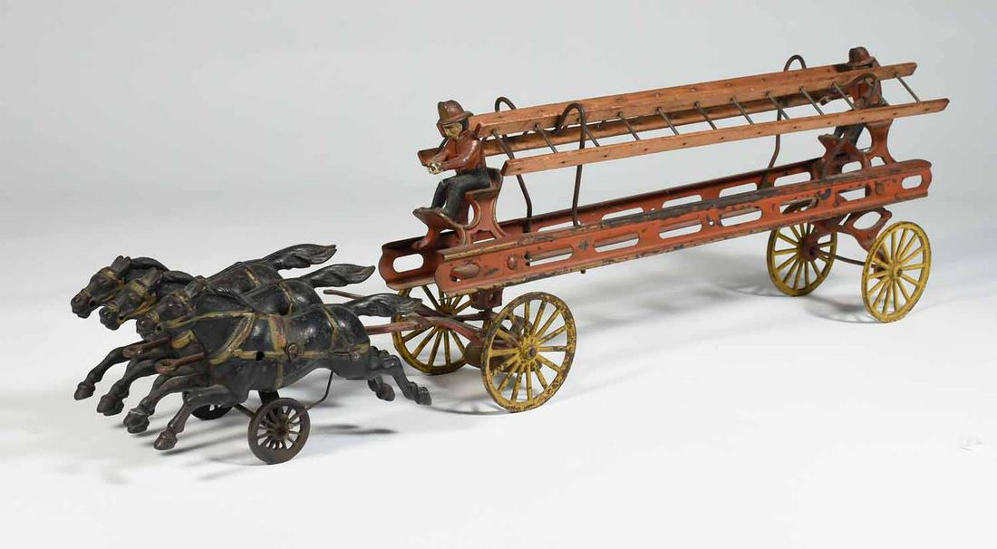 American Late 19th/ E. 20th C. Cast Iron & Pressed: American late 19th / E. 20th C fire ladder wagon horse drawn pull toy with original paint, team of three black horses pulling ladder wagon with two figures, 26” L X 7” H X 3.5” W.