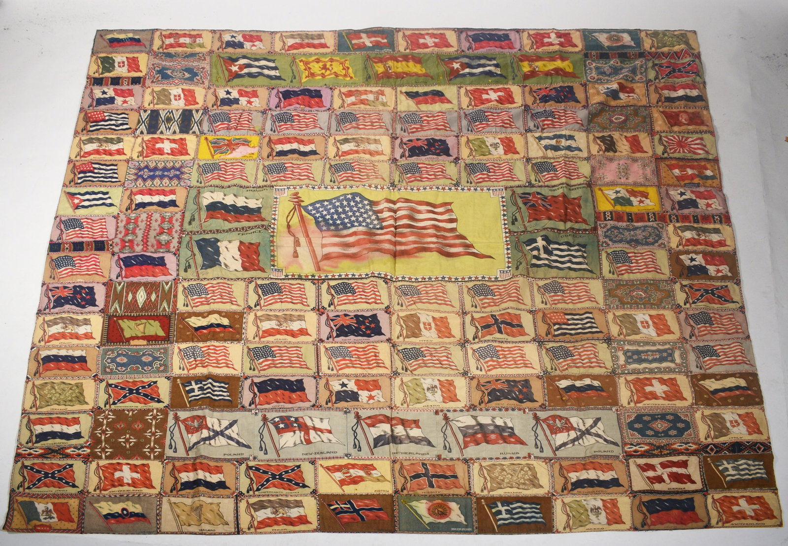 Cigar box felt flag quilt: Good Am. quilt with sewn cigar box felts depicting flags of many countries with American flag at front and center, Ca 1905-1920, approx. 72” X 78”
