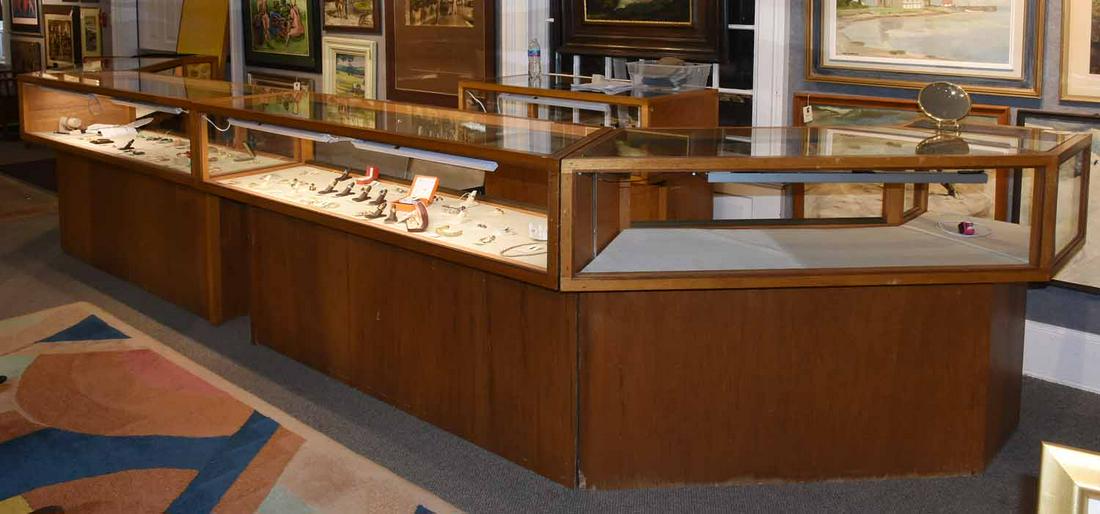 5 piece sectional wood & glass showroom jewelry display: Five piece sectional blonde wood and glass illuminated showroom jewelry display case, two larger sections (40” H X 72” L X 20” D) two medium sized angled pieces, (40” H X 64