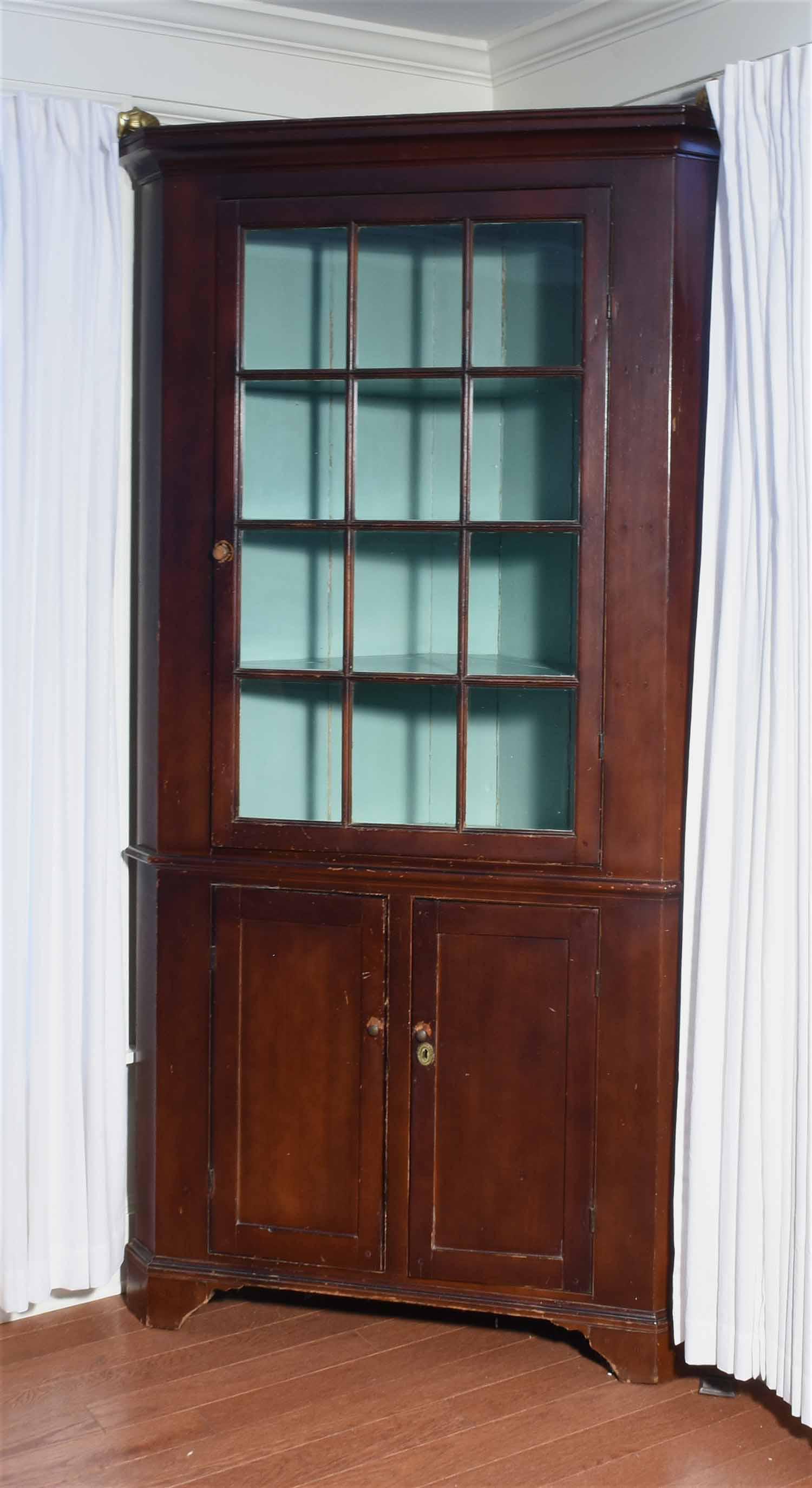 19TH C. NEW ENGLAND FEDERAL CORNER CUPBOARD: One-part solid pine construction with a twelve pane glass top door over double blind doors below on a bracket base. Dark brown paint. 84"H. x 43"W. x 21"D.