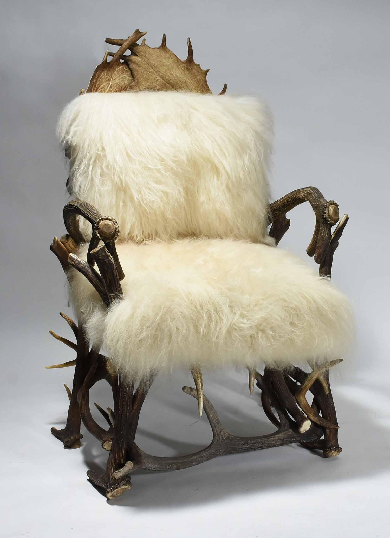 VINTAGE ANTLER ARMCHAIR: Covered with thick Mongolian sheep hide. 44.5" H X 29" W X 32" D