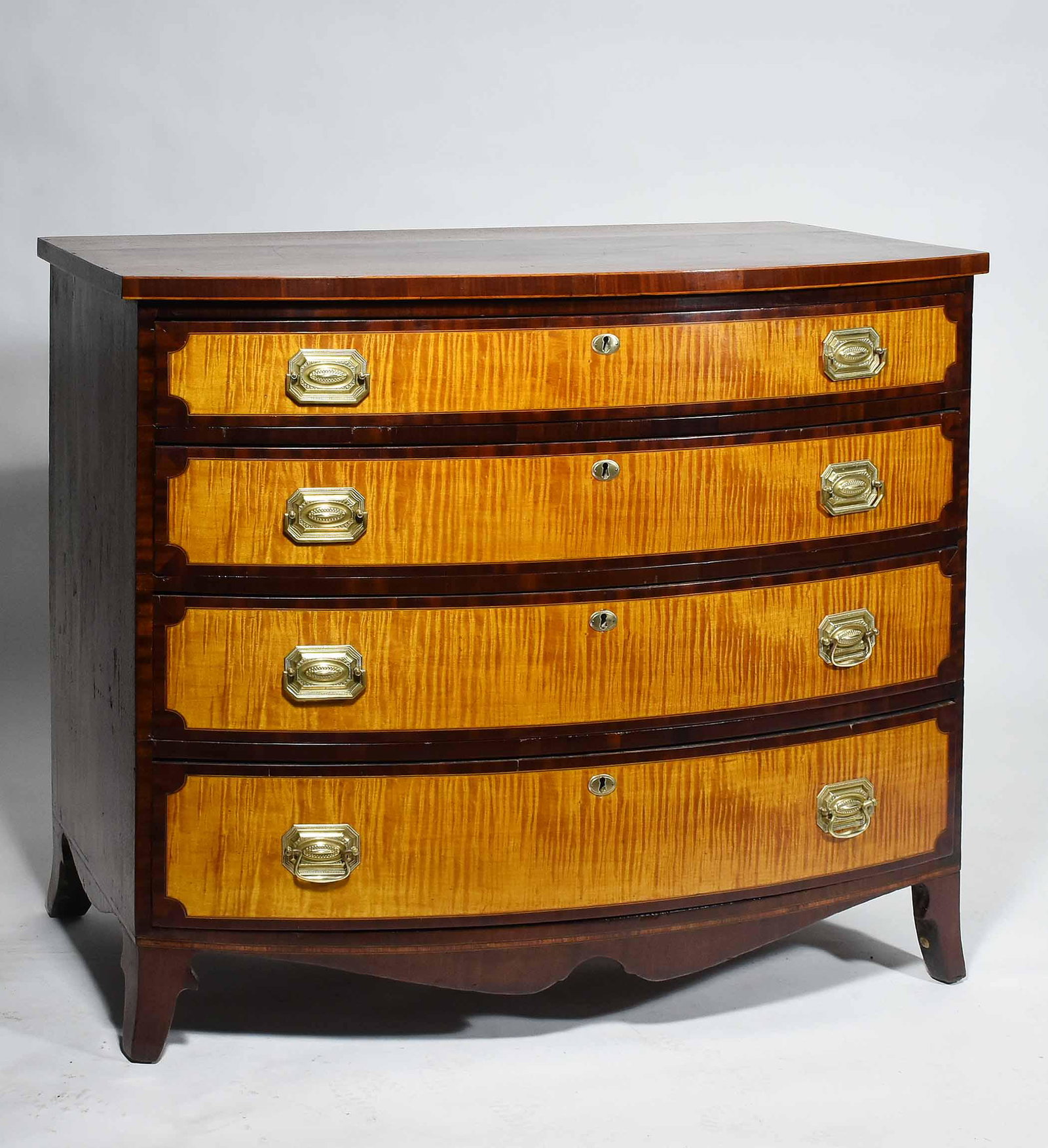 AMERICAN 19TH. C. FEDERAL BOW-FRONT CHEST: AMERICAN 19TH. C. FEDERAL BOW-FRONT CHEST. Four graduated drawers boldly embellished with strong tiger maple veneers, mahogany case on French feet and shaped apron. 37.25” H x 42.25” W X 24.5” D