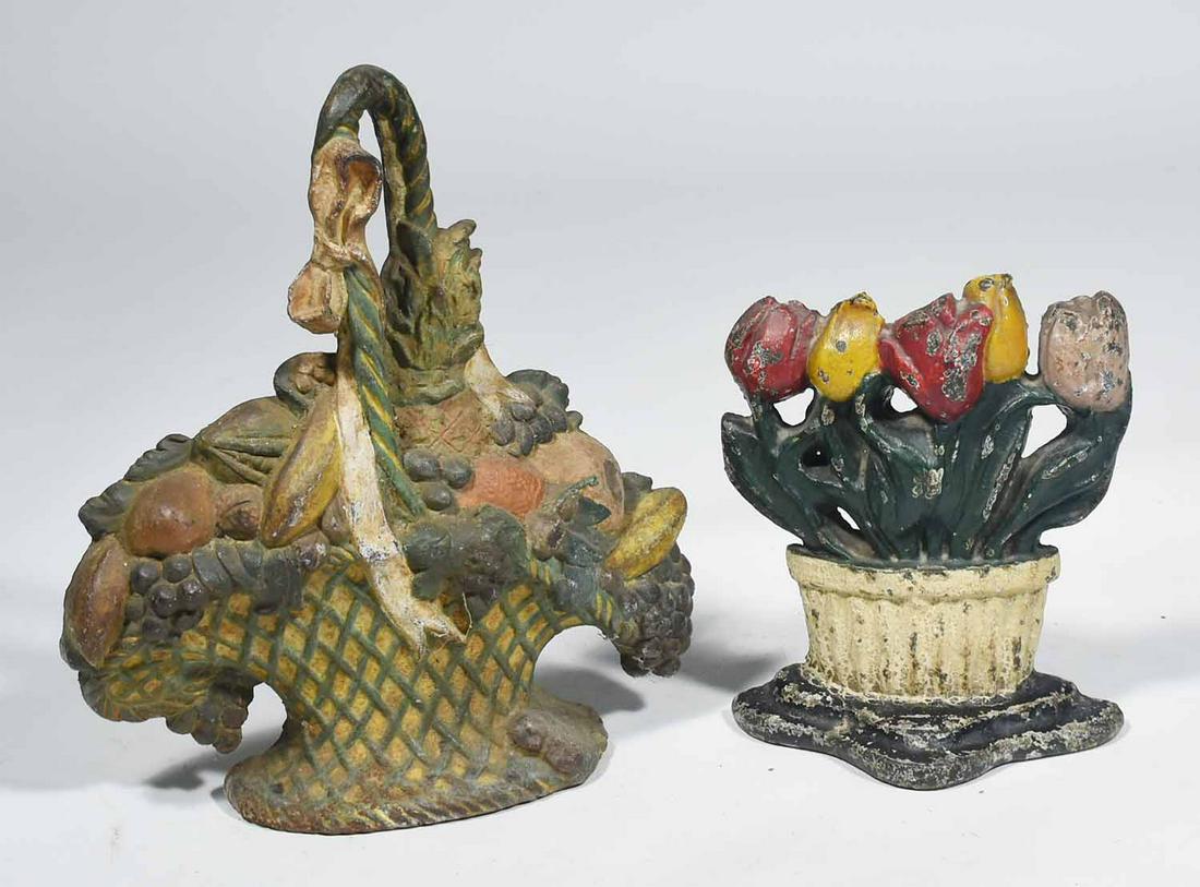 TWO PAINT-DECORATED CAST IRON FLOWER AND BASKET: TWO PAINT-DECORATED CAST IRON FLOWER AND BASKET DOORSTOPS. 13” H and 9” H.