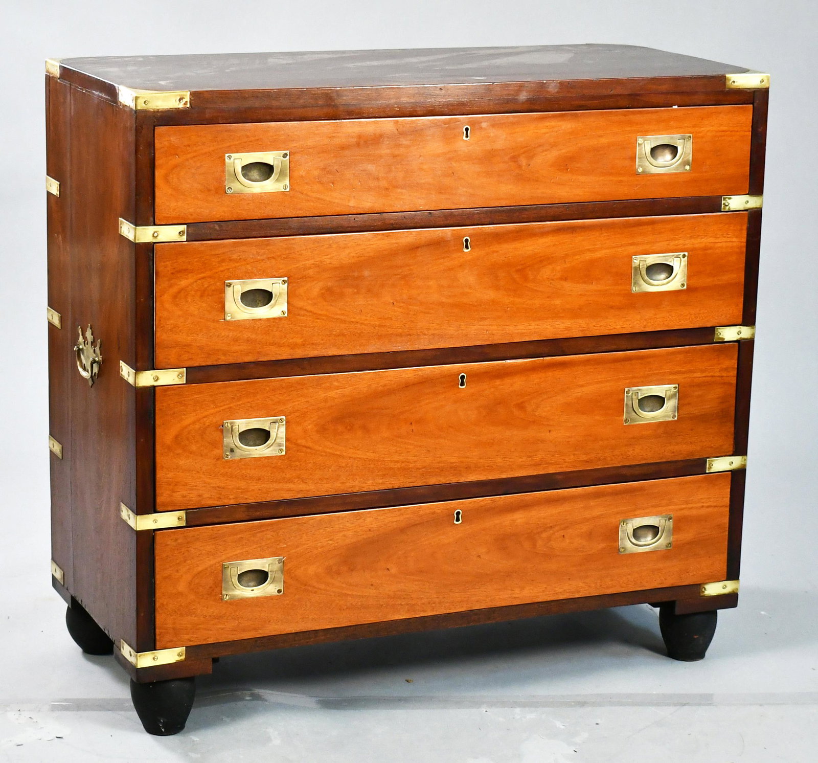 MAHOGANY BRASS BOUND CAMPAIGN CHEST.: Dark mahogany top and sides with lighter colored mahogany veneered drawer fronts, brass bound with turnip feet, 33”H x 34.5”W x 16”D