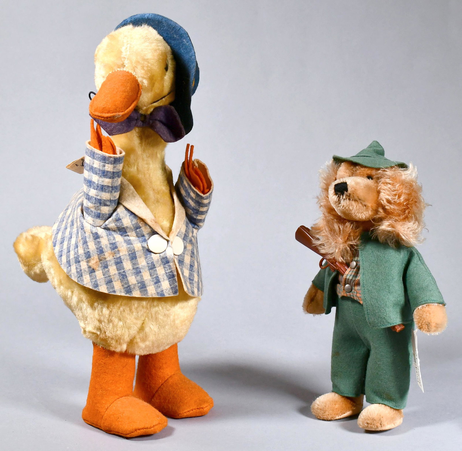 1971 STEIFF GENRE DOG AND GENRE GOOSE.: Named Waldili, dachshund hunter with plaster gun and green outfit. Goose is wearing blue and white jacket with blue felted hat, made by Gander Gund. Dog 9”H. Goose 13.5”H.